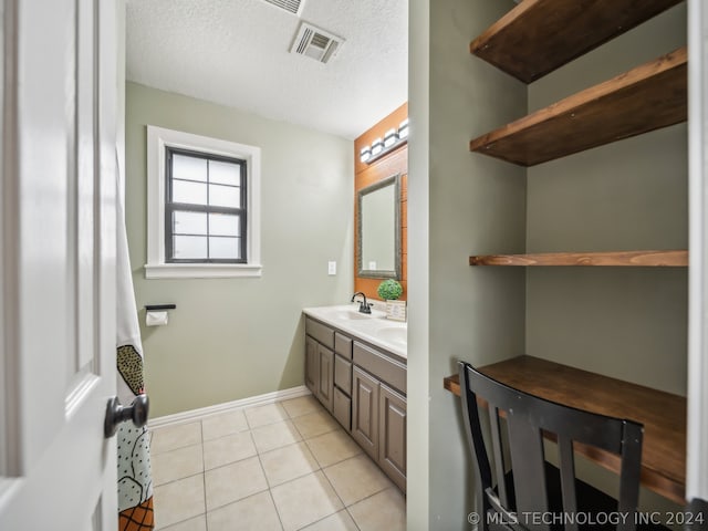 bathroom featuring a textured ceiling, vanity, and tile patterned flooring