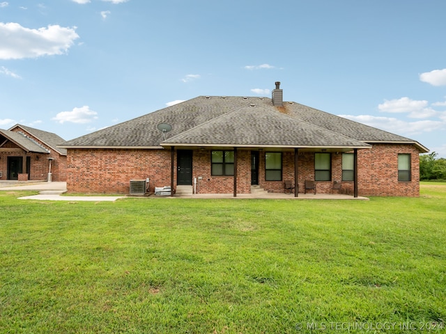 back of property featuring cooling unit, a yard, and a patio