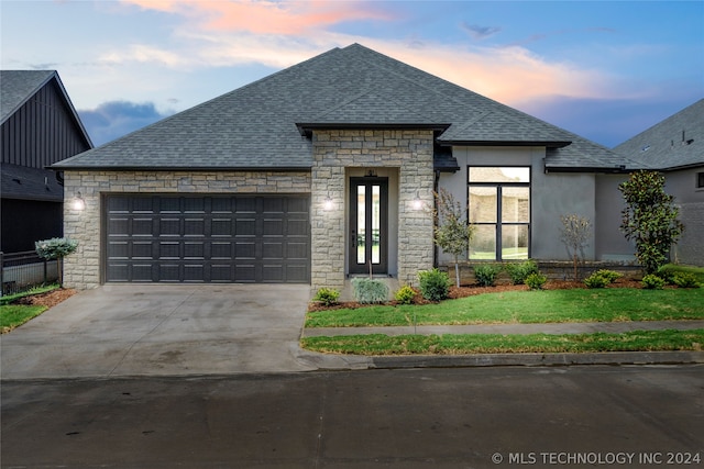 view of front of home featuring a garage and a lawn