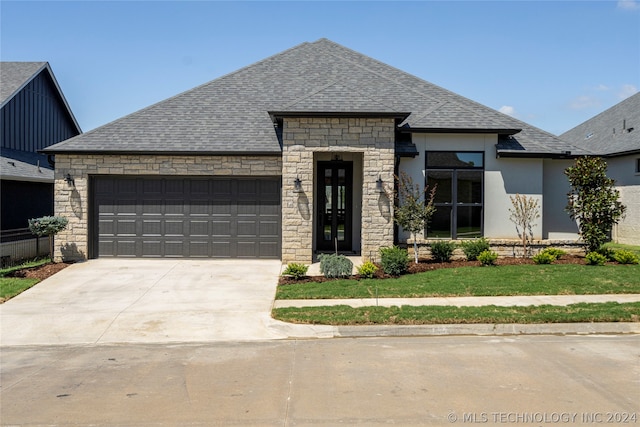 view of front of home with a garage and a front lawn