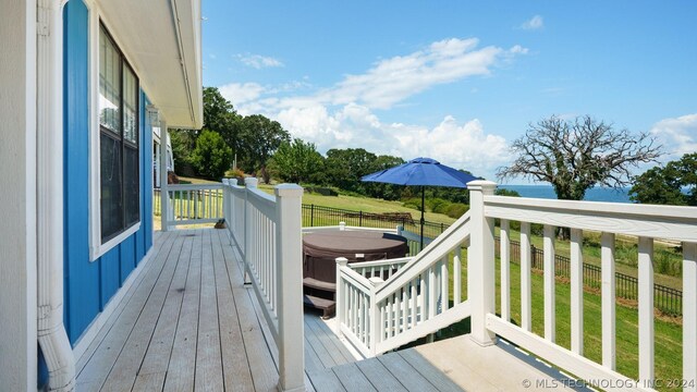 wooden terrace featuring a lawn and a hot tub