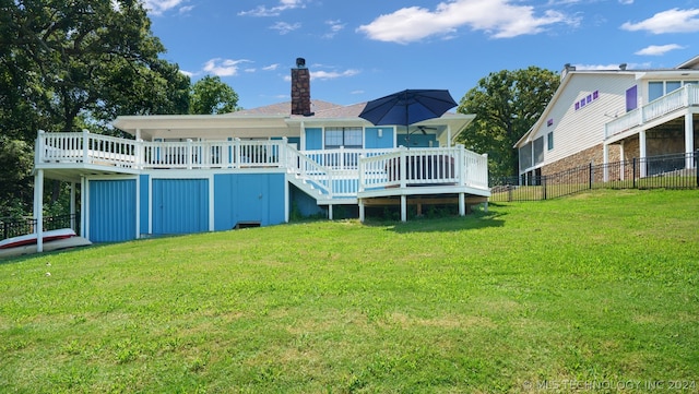 back of house featuring a deck and a lawn