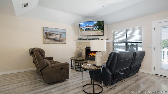 living room with a fireplace, hardwood / wood-style flooring, and vaulted ceiling