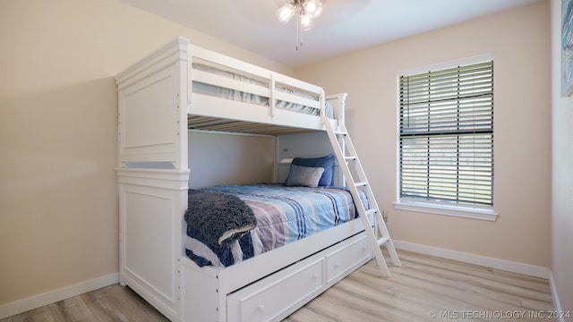 bedroom with multiple windows, ceiling fan, and light wood-type flooring