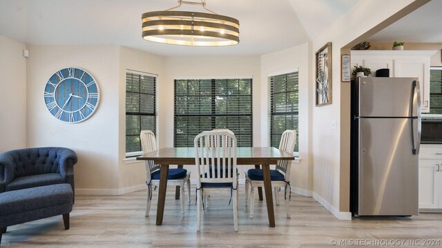 dining area with an inviting chandelier and light wood-type flooring