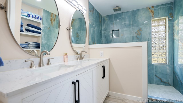 bathroom featuring dual vanity, tile patterned flooring, and a tile shower