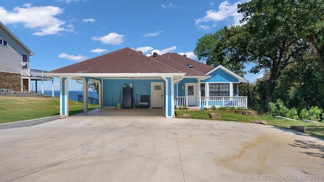 exterior space with a carport, covered porch, and a front lawn