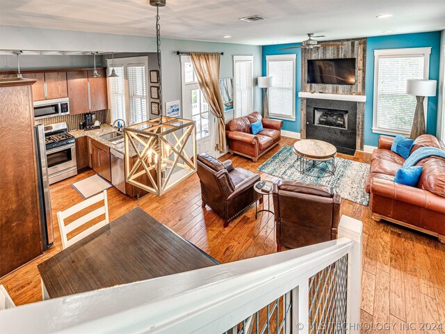 39 Boardwalk St, Carlton Landing, OK 74432 - living room featuring sink, light hardwood / wood-style flooring, a fireplace, and ceiling fan