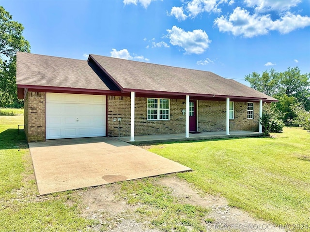 single story home with covered porch, a garage, and a front yard