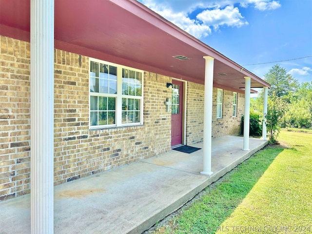 doorway to property with a lawn