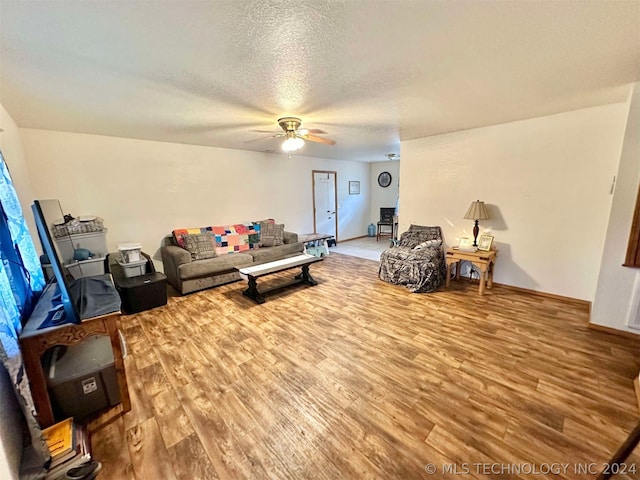 living room featuring a textured ceiling, ceiling fan, and light hardwood / wood-style floors