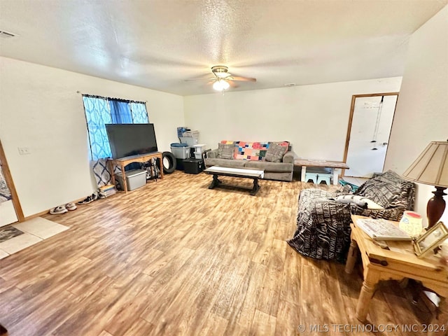 living room with wood-type flooring, a textured ceiling, and ceiling fan