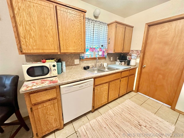 kitchen with sink, white appliances, and light tile patterned floors