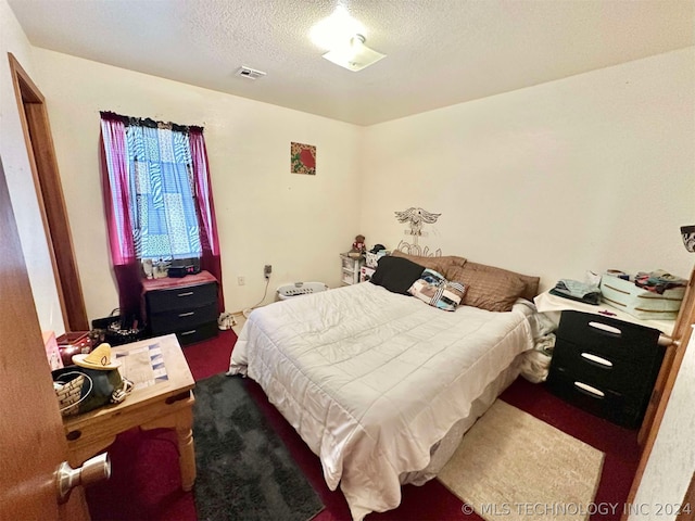 carpeted bedroom featuring a textured ceiling