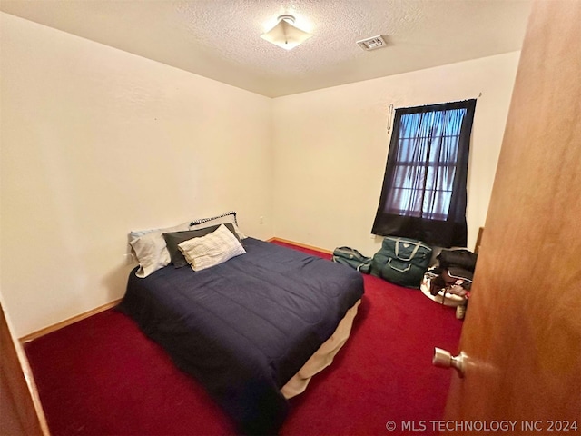 bedroom featuring carpet floors and a textured ceiling