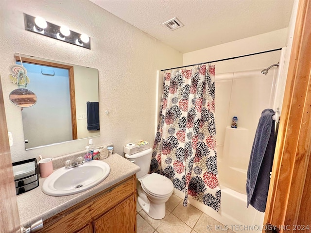 full bathroom featuring shower / tub combo with curtain, vanity, tile patterned floors, toilet, and a textured ceiling