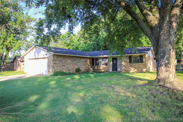 ranch-style home with a garage and a front lawn