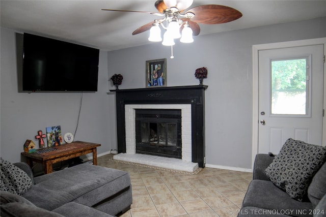 living room with a fireplace, ceiling fan, and light tile patterned floors