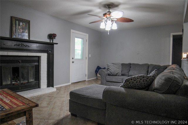 living room with a fireplace, light tile patterned floors, and ceiling fan