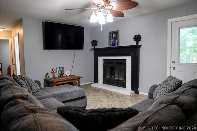 tiled living room with a fireplace and ceiling fan