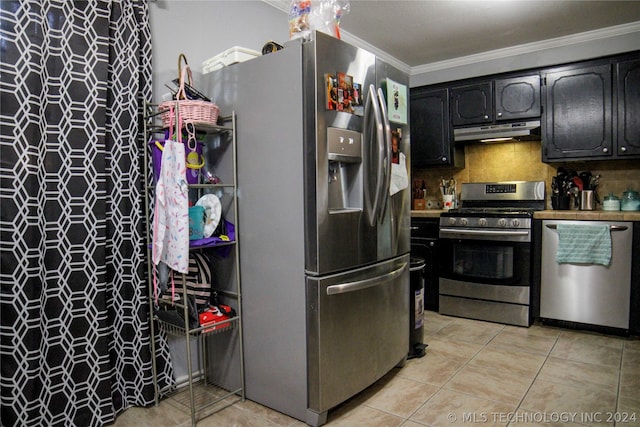 kitchen featuring ornamental molding, light tile patterned flooring, decorative backsplash, and stainless steel appliances