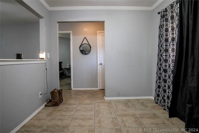 hallway with light tile patterned flooring and crown molding