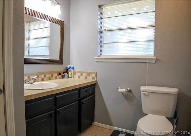 bathroom featuring vanity, tile patterned floors, toilet, and a healthy amount of sunlight