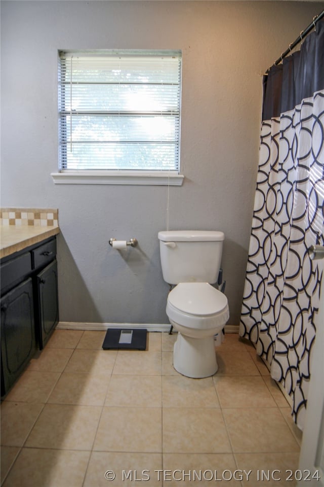 bathroom featuring vanity, tile patterned floors, and toilet