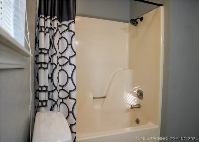 bathroom with toilet and shower / tub combo with curtain