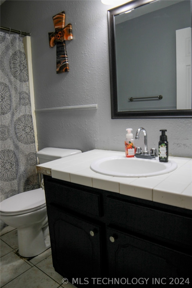 bathroom featuring vanity, toilet, and tile patterned floors