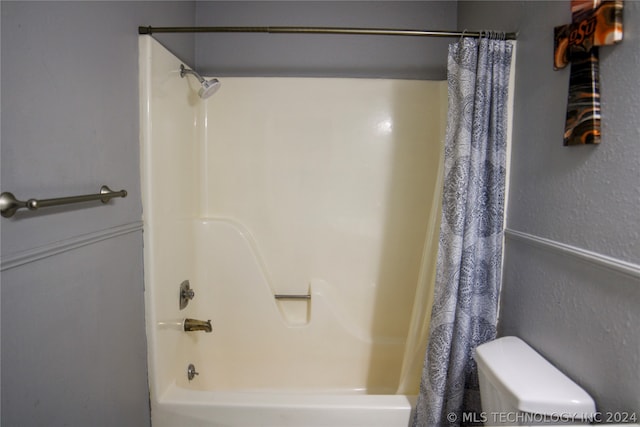 bathroom with toilet and shower / tub combo