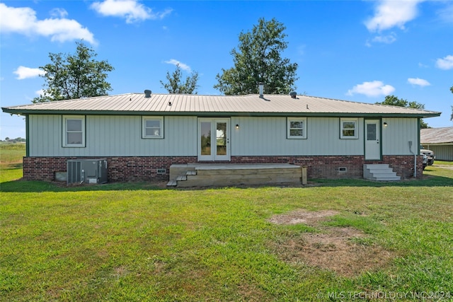 back of house with cooling unit, french doors, and a lawn