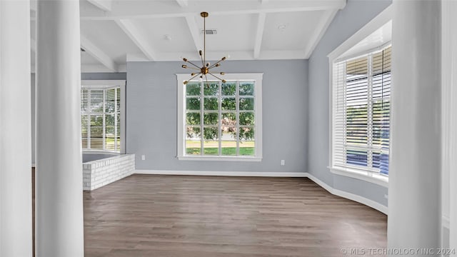 unfurnished dining area featuring wood-type flooring, plenty of natural light, beamed ceiling, and an inviting chandelier