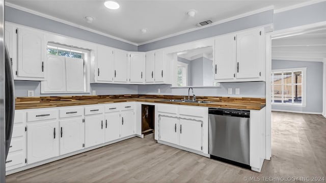 kitchen with butcher block countertops, stainless steel appliances, lofted ceiling, white cabinets, and sink