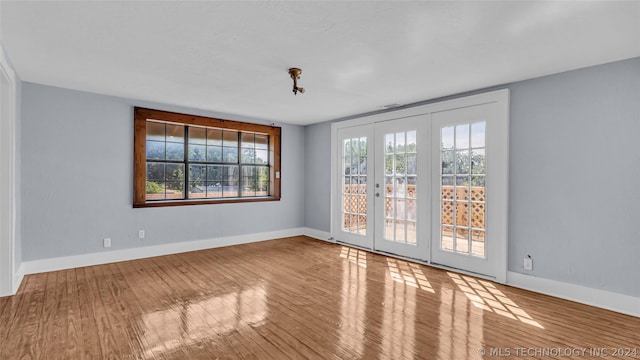 spare room featuring hardwood / wood-style floors and french doors