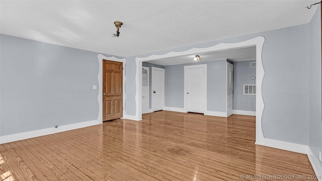 unfurnished room with hardwood / wood-style flooring