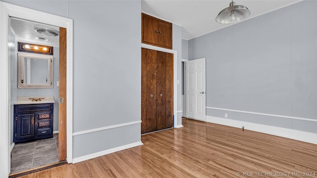 unfurnished bedroom featuring sink and light wood-type flooring