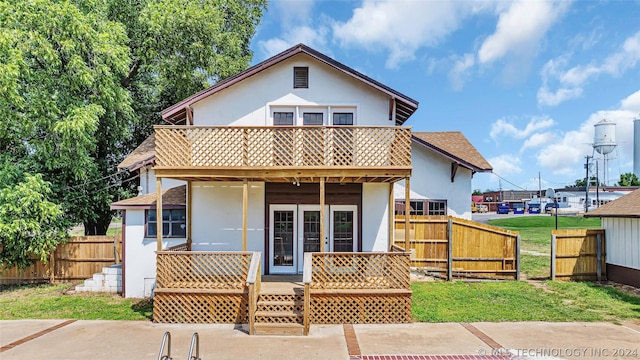 back of property with a patio area, a yard, and a balcony