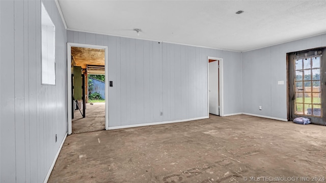 unfurnished room with wood walls