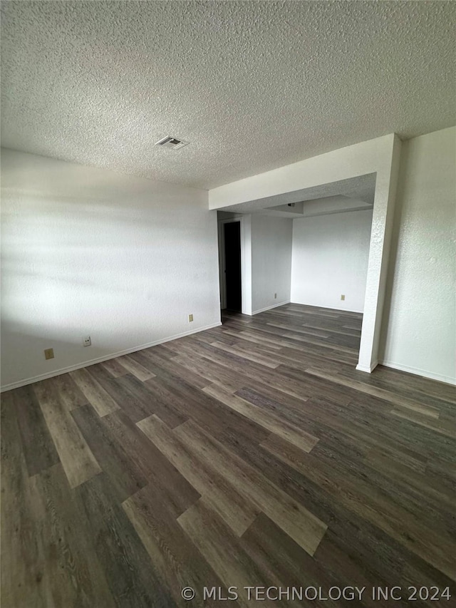 unfurnished bedroom with a closet, dark hardwood / wood-style flooring, and a textured ceiling