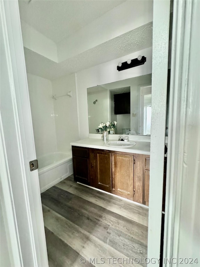 bathroom with shower / bathing tub combination, vanity, and hardwood / wood-style flooring