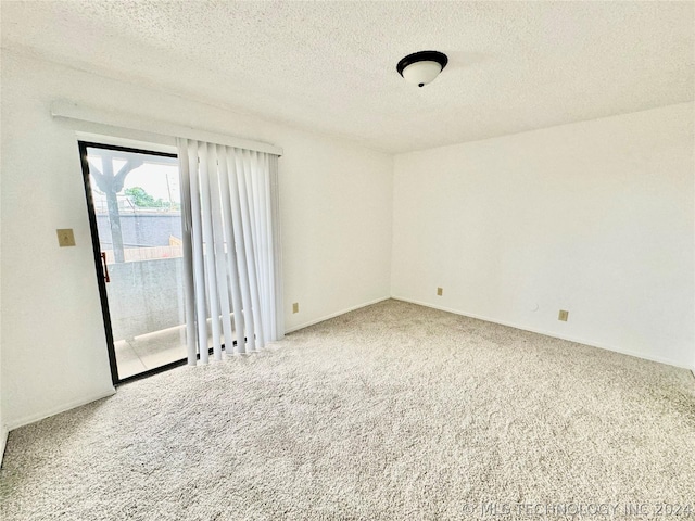 carpeted empty room with a textured ceiling