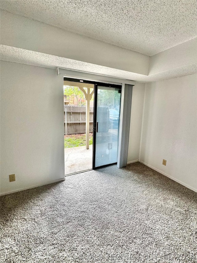 carpeted empty room featuring a textured ceiling