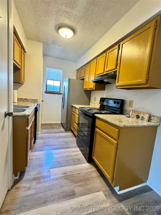 kitchen with light wood finished floors, under cabinet range hood, electric range, light countertops, and a textured ceiling