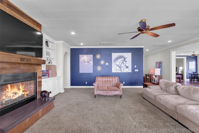 living room with crown molding, carpet, built in features, and ceiling fan