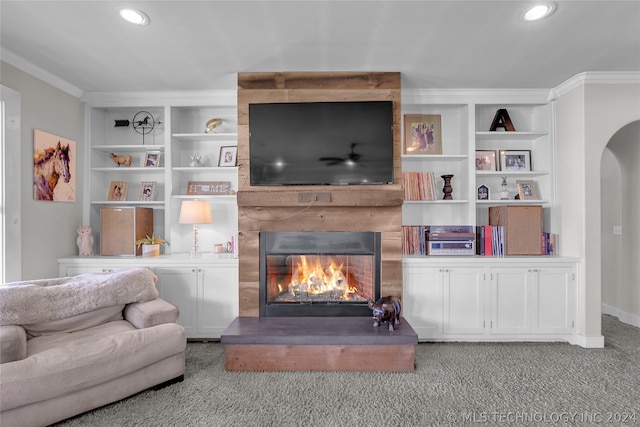 living room with a fireplace, built in shelves, crown molding, and carpet floors