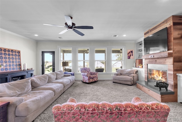 living room featuring a large fireplace, carpet, ceiling fan, and plenty of natural light