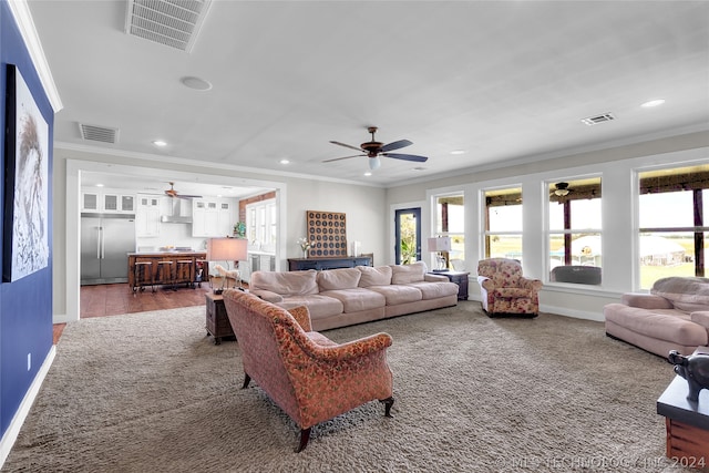 living room featuring wood-type flooring, ceiling fan, and crown molding