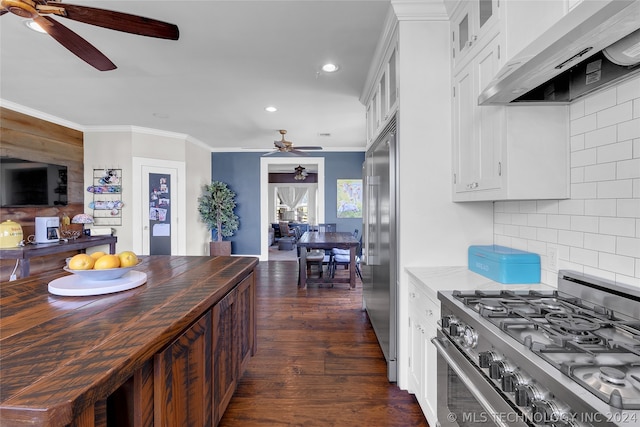 kitchen with tasteful backsplash, wall chimney range hood, ceiling fan, premium appliances, and dark hardwood / wood-style flooring