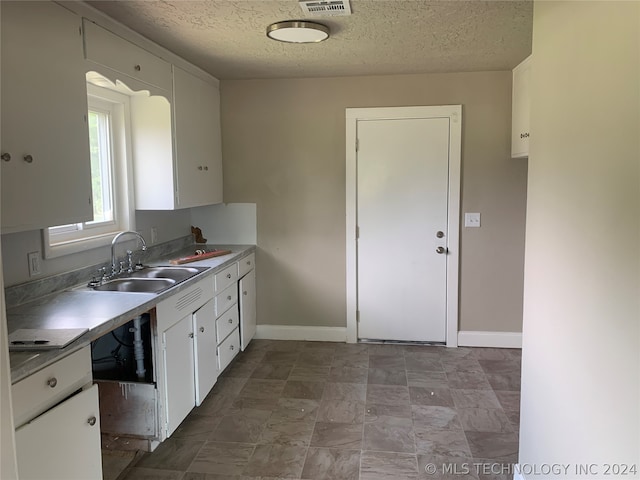 kitchen with sink, tile patterned floors, a textured ceiling, and white cabinets